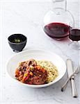 Risotto and Ossobucco (braised veal shank) on plate with red wine, studsio shot