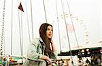 Teenage girl sitting on amusement park ride, Germany