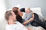 Happy parents with son on sofa