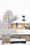 Man cleaning snow from garage roof