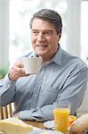 Smiling mature man eating breakfast