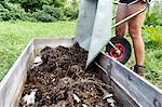 Woman emptying wheel-barrow