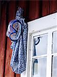 Swimsuit and diving goggles hanging near window