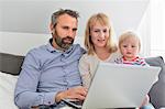 Parents with daughter using laptop