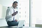 Businessman using cell phone in office