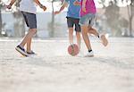 Children playing with soccer ball in sand