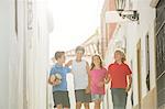 Children with soccer ball walking in alley