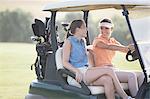 Women driving cart on golf course