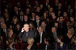 Man talking on cell phone in theater audience