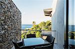 Table and chairs on luxury balcony overlooking ocean