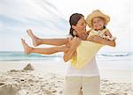 Mother holding daughter on beach