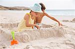 Children making sandcastle on beach