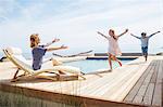 Children running to grandmother by pool