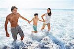 Family playing in waves at beach