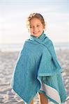 Girl wrapped in towel on beach