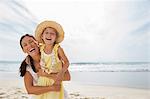 Mother and daughter laughing on beach