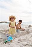 Children building sandcastle on beach