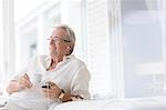 Senior man listening to earphones on patio