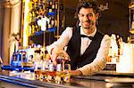 Well dressed bartender pouring bourbon at luxury bar