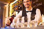 Portrait of well dressed bartender pouring bourbon in luxury bar