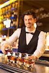 Well dressed bartender pouring bourbon in luxury bar