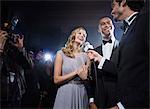 Well dressed celebrity couple being interviewed at red carpet event