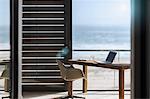 Desk and chair in modern home office overlooking ocean