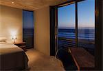 Modern bedroom overlooking ocean at dusk