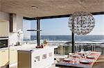 Kitchen and dining room in modern house overlooking ocean