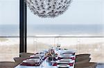 Set table in modern dining room overlooking ocean