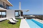 Lounge chairs and lap pool outside modern house