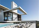 Rocks along lap pool outside modern house