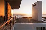 Modern house overlooking ocean at sunset