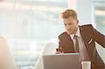 Businessman using cell phone in office