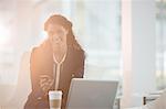 Businesswoman using cell phone in office