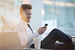 Businessman using cell phone in office