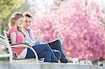 Couple relaxing together on park bench