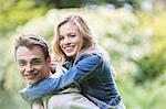 Man carrying girlfriend piggyback outdoors