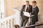 Businessmen using laptop on steps