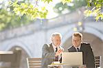 Businessmen working at sidewalk cafe