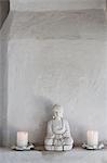 Buddha figurine and candles on ledge