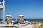 Lounge chairs on patio overlooking ocean