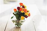 Close up of multicolor roses in vase on table