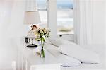 Vase of flowers and lamp in white bedroom