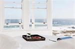 Breakfast tray and magazine on bed overlooking ocean