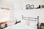 Shelf above bed in white bedroom