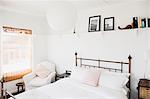 Shelf above bed in white bedroom