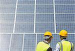 Workers examining solar panels in rural landscape