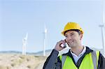 Worker using walkie talkie in rural landscape