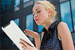 Young woman blowing kiss at digital tablet